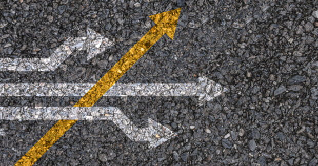 Yellow arrow cross direction with white arrow on road asphalt.